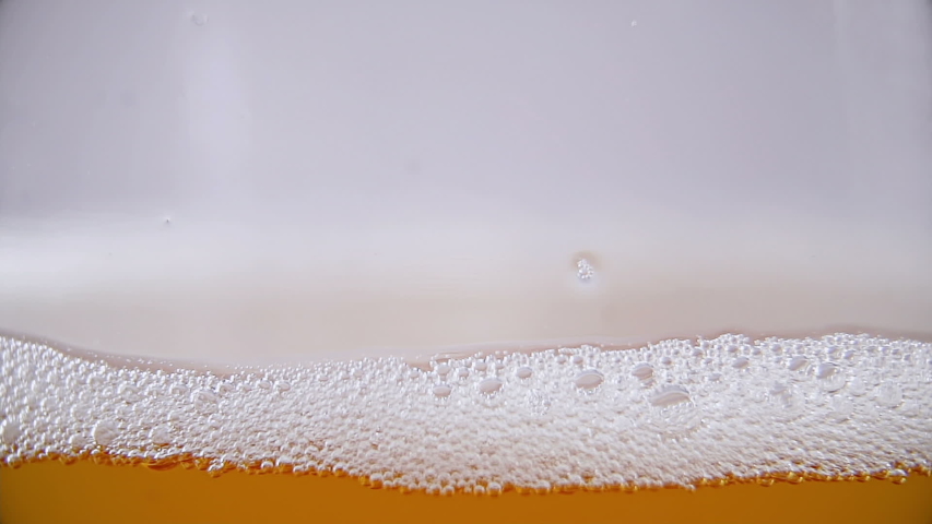 Macro shot of Light lager beer being poured into the glass filling the screen up with liquid and begin bubbling | Shutterstock HD Video #1045285654
