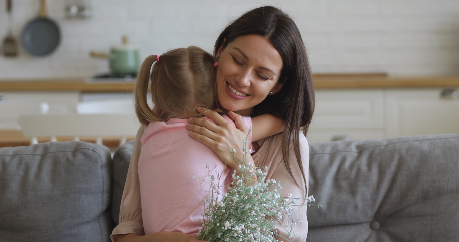 Sincere young mother embracing cuddling little preschool daughter. Happy 30s mom feelings thankful to small kid girl for birthday 8 march international woman s day congratulations, holding flowers. Royalty-Free Stock Footage #1045292002