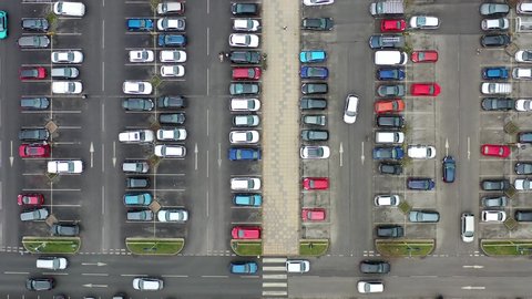 Aerial footage of a busy car park in the town of Seacroft in Leeds West Yorkshire in the UK, showing cars parking and looking for parking spaces in the Tesco supermarket carpark
