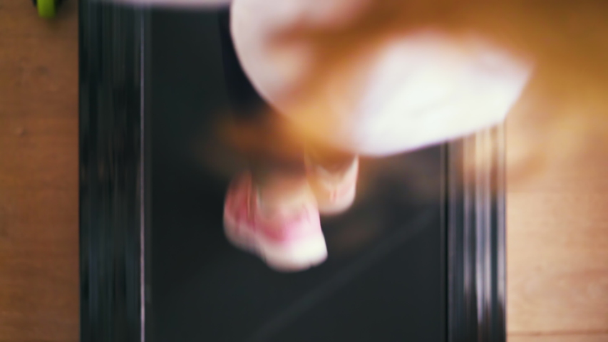 CU: strong little girl in white t-shirt and pink sneakers runs on modern running machine at home close upper view