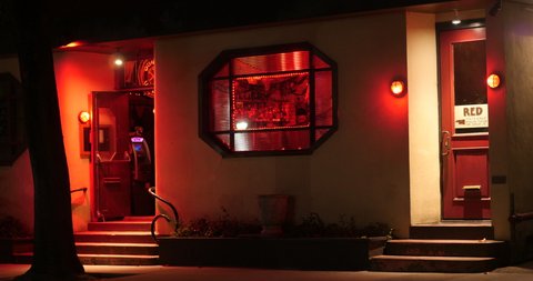 A locked off night time shot of a bar with red lighting. Matching day shot available. 10bit 4k Prores 422