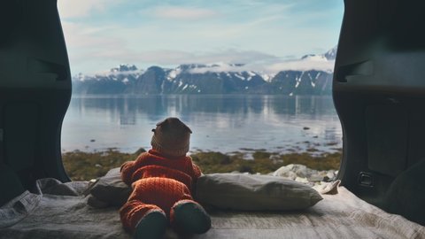 Infant baby family travel road trip child enjoying mountains and sea view from camping car travel lifestyle kid outdoor in Norway