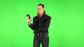 Guy girl angrily talking for video chat using mobile phone . Green screen