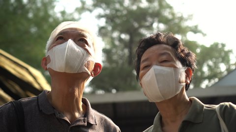Hopeless Asian Chinese elder couple aware of 2019 ncv outbreak and smog situation wear preventing mask