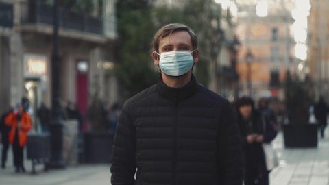 Pandemic in china, portrait of a young tourist man wearing protective mask on street crowd people. the concept health and safety, N1H1 coronavirus, virus protection coronavirus quarantine