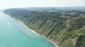 This aerial video captures the coastline of a mountain connecting to the sea.