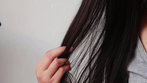 Young Asian woman with hair comb on white background, closeup problem hair. Tangled hair.
