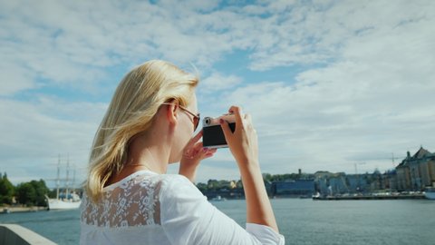 Young woman photographer takes pictures of view of Stockholm