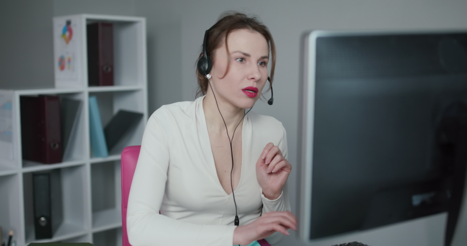 Young Beautiful Women Call Center Wear Headset and Working with Computer while Consulting Customer with Online Problem. Support and Operator Service Business Representative Concept. Online marketing. Royalty-Free Stock Footage #1045353061