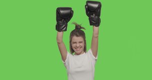 Girl boxer iwith boxing gloves celebrating victory over Green Screen, Chroma Key. 4k raw video footage slow motion 60 fps