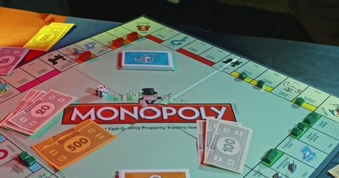 New York, New York / United States- January 7 2020: Monopoly the board game. Pan of game with money, pieces, houses and hotels on the board.