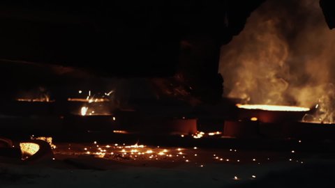 Beautiful Factory Scene Shot With Bright Fire, Sparks and Smoke, Hot Metal, Dark Background. Abstract Flame, Metal Production, Forging, Slow Motion 