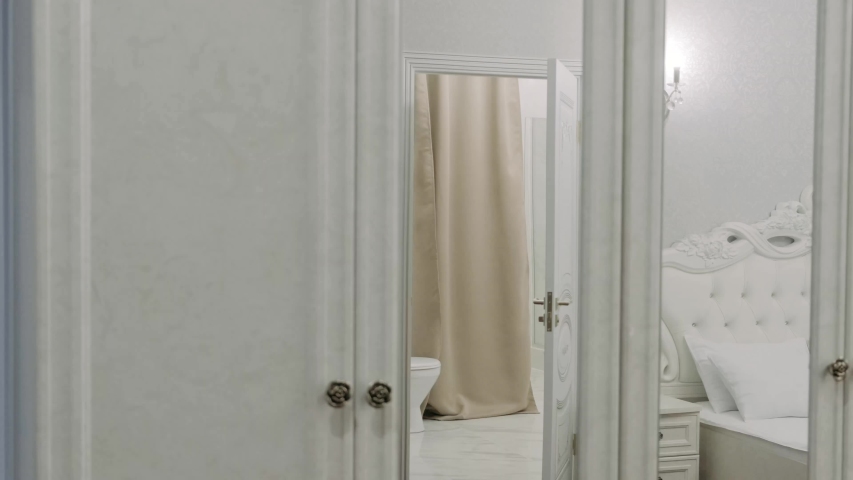 A woman and a man in white bathrobes go to the room from the bath