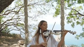 Young adult violinist girl playing classical music on modern violin