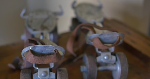 A pair of vintage metal roller skates on a wooden table
