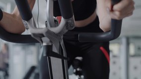 Tilt up video of tired woman working out with exercise bike.  Shot with RED helium camera in 8K