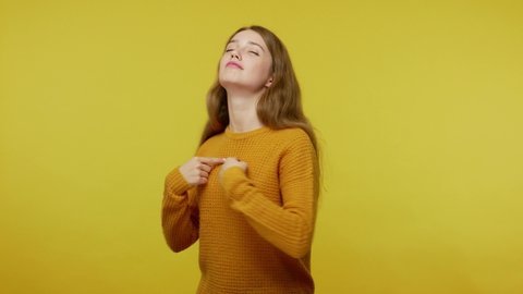This is me! Proud egoistic self-confident girl with beautiful appearance in casual clothes pointing herself and looking haughtily with arrogance. indoor studio shot isolated on yellow background