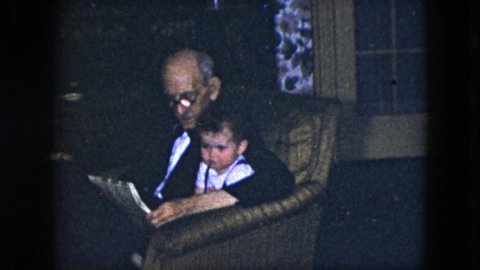 CLEVELAND OHIO-1951: Grandpa Sits Grandson On His Lap And Reads Him A Story At They Sit Together
