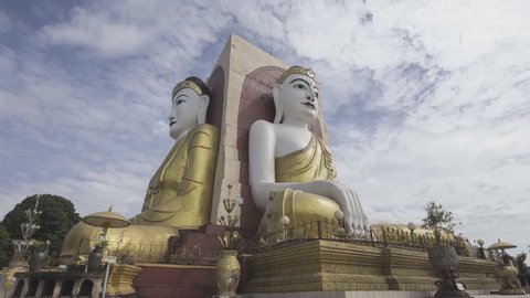Big four giant Buddha statues or Kyaik Pun pagoda on blue sky at Bago , Myanmar (time-lapse)