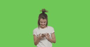 Beautiful young woman reading text message on her mobile phone over green screen background, chroma Key 4k raw video footage slow motion 60 fps