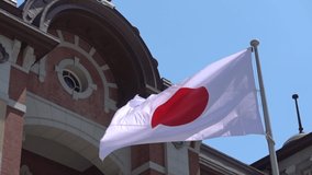 Close up HD video of the Japan flag waving in the wind outside Tokyo station.