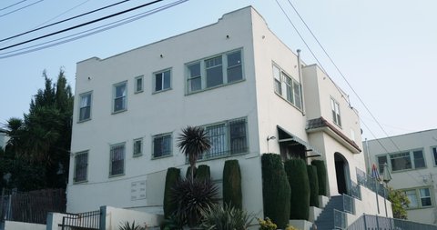 Los Angeles, CA, USA 01/26/2020 - A typical California apartment exterior, establishing shot with a locked off angle during the day. Run down building with white stucco exterior.