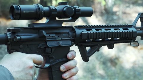 Rifle AR 15 with an eye close up shoots many times, soldier fires at opponents