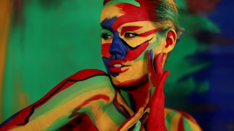 Woman with color face art and body paint. Colorful portrait of the girl with bright make-up and bodyart.