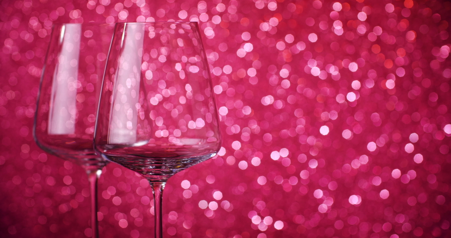 Red wine is poured into glasses on the background of the bokeh. Close-up of filling wine glass with red wine. Slow motion shot. 4K.