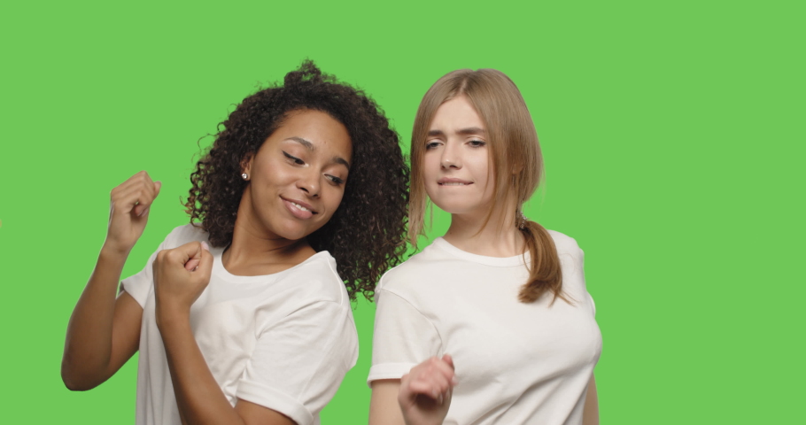 two beautiful girls dancing and smiling on chroma key background . Happy women having fun on a Green Screen, 4k video footage slow motion 60 fps Royalty-Free Stock Footage #1045536418