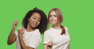 two beautiful girls dancing and smiling on chroma key background . Happy women having fun on a Green Screen, 4k video footage slow motion 60 fps