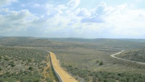 Aerial footage of the Israeli Palestine wall divide between Israeli and Arab territory. Amazing view of the hills. Boom, tilt down