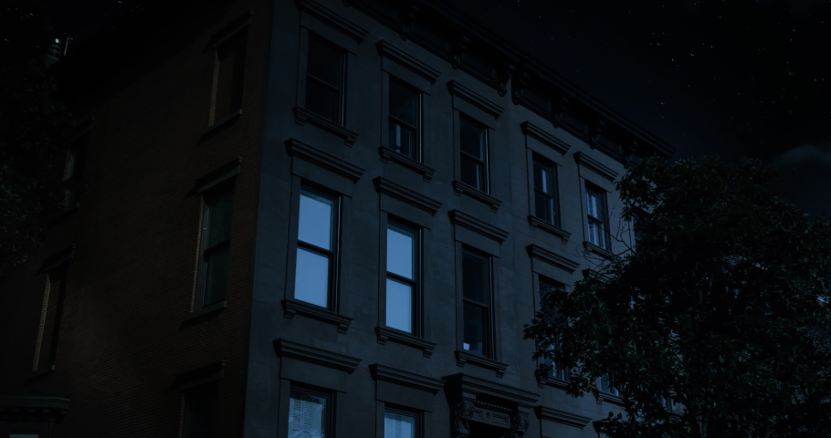 A nighttime exterior establishing shot of the upper floors of a typical Brooklyn brownstone residential home as a room lights up then turns off.	Day matching: 1045545877 | Shutterstock HD Video #1045548061