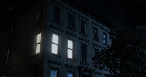 A nighttime exterior establishing shot of the upper floors of a typical Brooklyn brownstone residential home as a room lights up then turns off.	Day matching: 1045545877