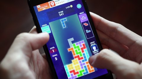 Bangkok, Thailand - January 23, 2020 : Smartphone user playing EA's Tetris game on iphone 7.