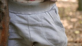 After a hike autumn in the forest the baby happily puts his acorn in his pants pocket