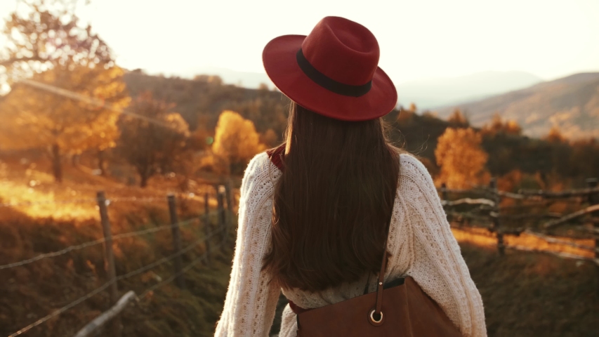 Outdoor autumn fashion portrait of young beautiful confident woman walking at sunset in mountain landscape. Royalty-Free Stock Footage #1045572568