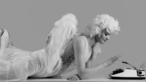 Smiling funny angel typing letter to lovers. Black and white. Christmas and Valentine's Day