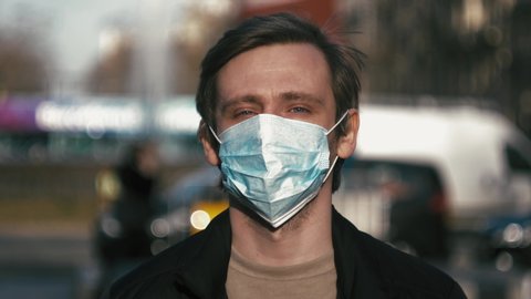 Pandemic, portrait of a young tourist man wearing protective mask on street crowd people. the concept health and safety, N1H1 coronavirus quarantine, virus protection