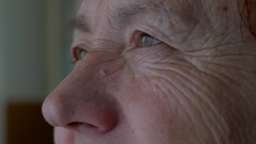 The face and eyes of an old man. Large wrinkles on the face of an old woman. Face close up. A senior citizen looks into the distance. Royalty-Free Stock Footage #1045603138