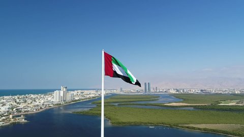 Rasal khaima, United Arab Emirates - 11 / 13 / 2019 : U.A.E Flag in between the city of Rasal Khaima, drone shot