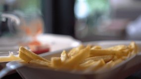 4k video of people eat Junk food French fries dip in tomato sauce.	