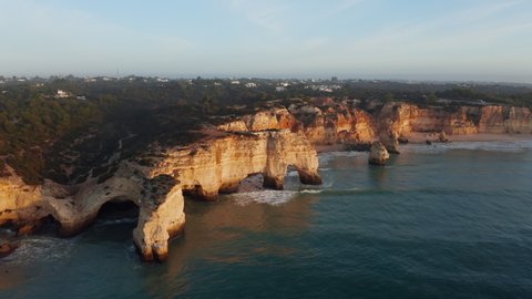 Aerial view of cliff with arch rock at Praia da Marinha at sunrise