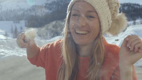 Happy young woman eating cheese fondue in Switzerland enjoying the Alps and snowcapped mountains in winter season holidays. People food tradition local concept 