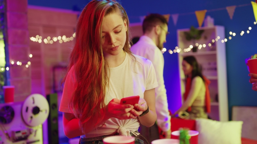 Unsociable blonde girl browsing on smartphone media news suffering lack of attention from friends staying aside on night disco party. | Shutterstock HD Video #1045646146