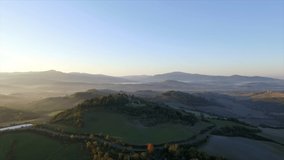 4k aerial drone right to left flight footage at early morning grazing light over the green Tuscany countryside hills between Volterra and Cecina.