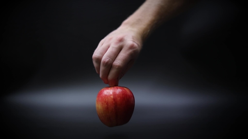 Slow Motion Hand Spinning a Ripe Red Apple on a Black Surface - Powered by Shutterstock - Get 15% off with code: PIKWIZARD15