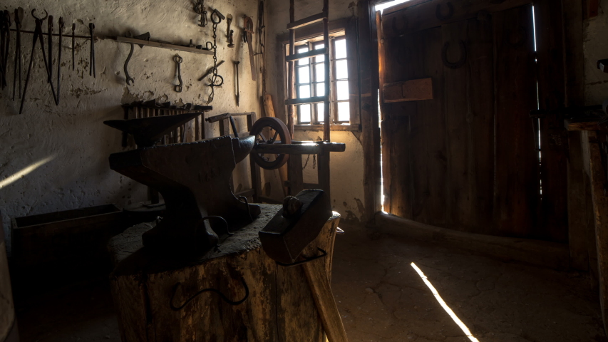 Authentically decorated forge with tools for the production of metal products. Anvil and forge tools. Motion time lapse. 4K. 
