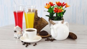 Juice glasses with coffee cup with white kettle on spinning table background. FHD.