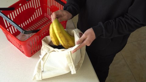 Young man are shopping in the supermarket. Reusable Canvas Fabric Grocery Bag. Shopping Without Plastic Bags In Grocery Store. Zero waste